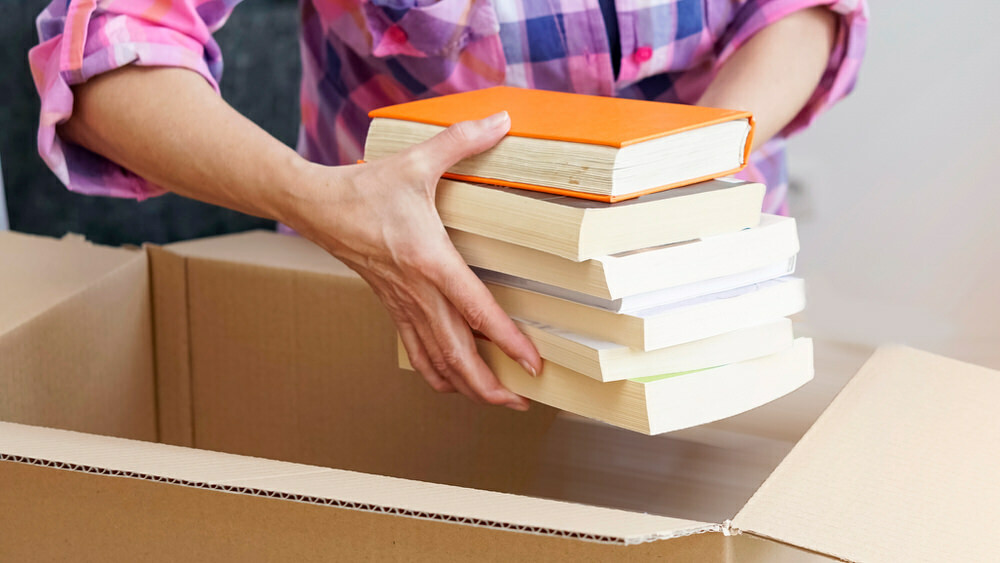 woman placing book the box